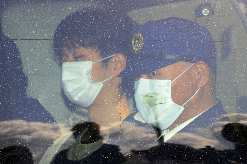A man (L), whom local media have named as 24-year-old Ryuji Kimura, who is believed to have thrown an explosive toward Japan's Prime Minister Fumio Kishida, leaves Wakayama Nishi Police Station in Wakayama on April 17, 2023. Photo by JIJI Press / AFP