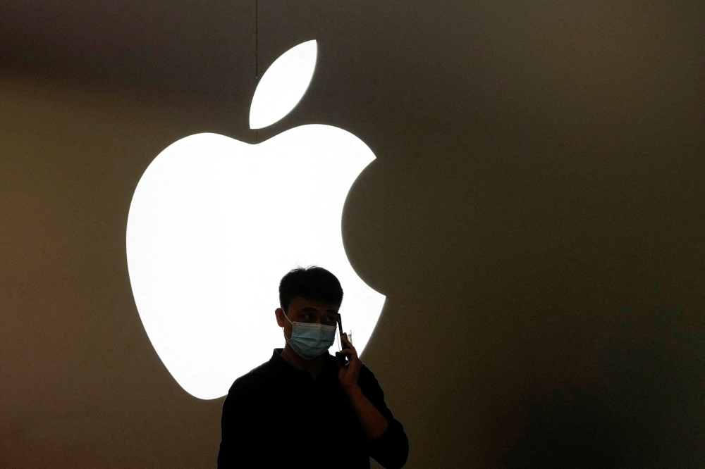 File photo: A man talks on a phone in front of an Apple logo outside its store in Shanghai, China, November 7, 2022. (REUTERS/Aly Song)

