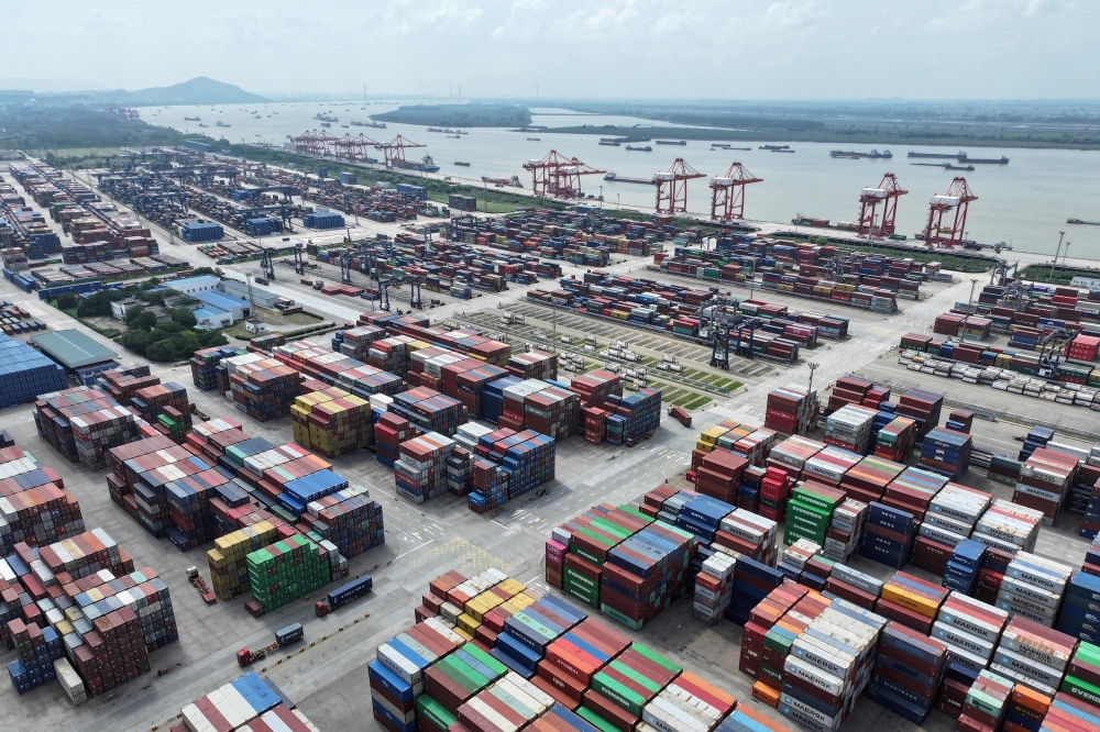 In this photo taken on August 6, 2023 a truck drives between containers at Nanjing port in Nanjing, in China痴 eastern Jiangsu Province. Photo by STRINGER / AFP