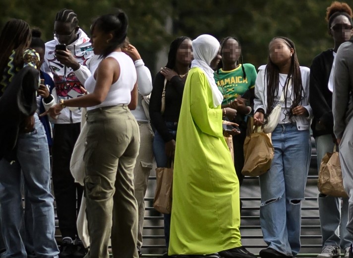 A young woman wearing an abaya speaks with others on a street in Nantes, western France on August 31, 2023. (Photo by Loic Venance / AFP)

