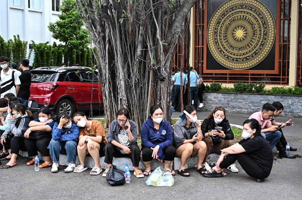 Relatives wait outside a funeral house during the identification of victims of the major fire at an apartment block in Hanoi on September 13, 2023. (Photo by AFP)

