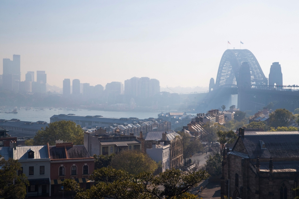 Sydney Harbour Bridge is seen shrouded by smoke in Sydney on September 13, 2023. (Photo by Steve Christo / AFP)
 
