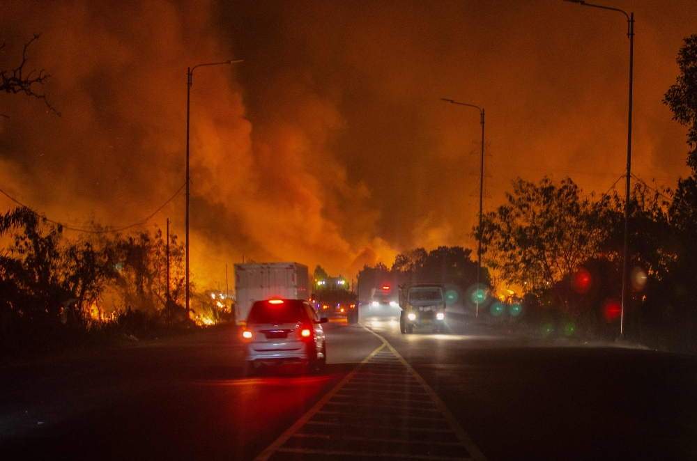 A wildfire burns along the road in Ogan Ilir, South Sumatra, on September 14, 2023. Photo by Al ZULKIFLI / AFP