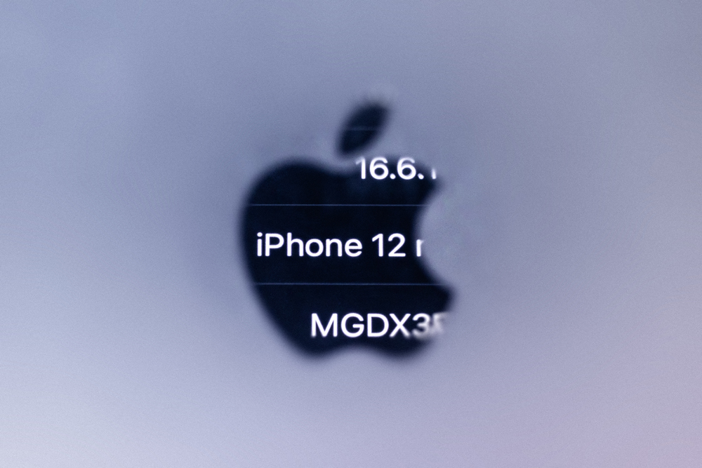 This illustration photograph taken on September 13, 2023 in Paris with a macro lens shows reversed information of an iPhone 12 reflected in the Apple logo of an iPhone, as French regulators ordered Apple to halt sales of the iPhone 12 and to fix existing handsets for emitting too much electromagnetic radiation. Photo by JOEL SAGET / AFP