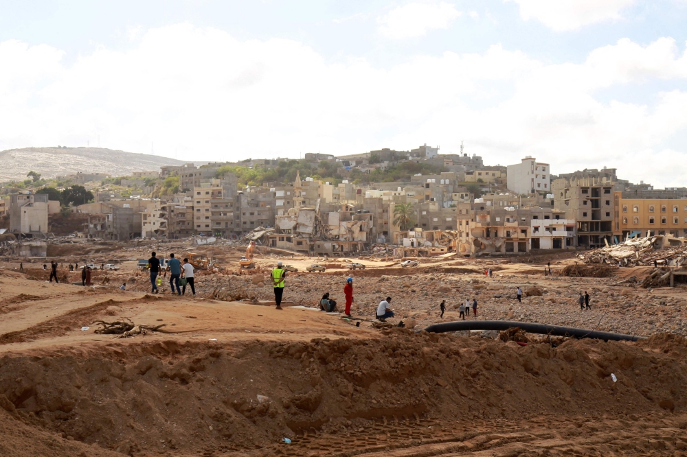 People walk along a street swept away by floods after the Mediterranean storm 