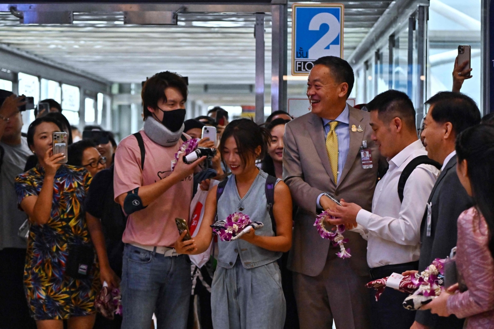 Thailand's Prime Minister Srettha Thavisin (4th R) greets Chinese tourists as they arrive at Suvarnabhumi International Airport in Bangkok on September 25, 2023. (Photo by Lillian Suwanrumpha / AFP)