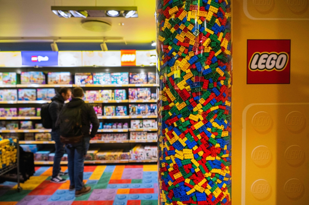 This file photo taken on November 29, 2022 shows people checking LEGO boxes at a shop in the hotel LEGOLAND in Billund, Denmark. Photo by Jonathan NACKSTRAND / AFP