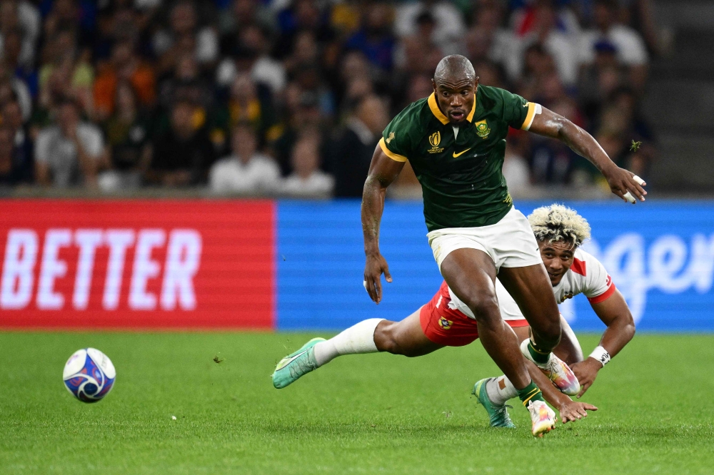 South Africa's wing Makazole Mapimpi (L) fights for the ball with Tonga's wing Fine Inisi (R) during the France 2023 Rugby World Cup Pool B match between South Africa and Tonga at Stade Velodrome in Marseille, south-eastern France, on October 1, 2023. (Photo by CHRISTOPHE SIMON / AFP)

