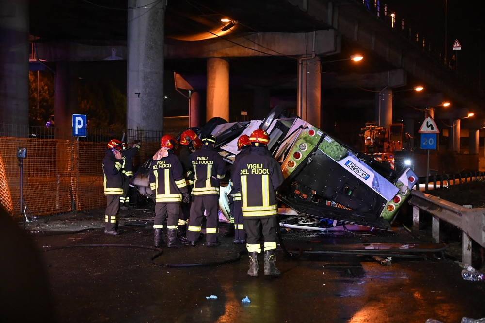 Firefighters work on the site of a bus accident on October 03, 2023 in Mestre, near Venice. (Photo by Marco Sabadin / AFP)