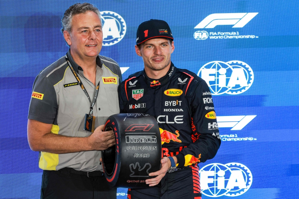Red Bull Racing's Dutch driver Max Verstappen is awarded the Pole Position trophy after the qualifying session ahead of the Qatari Formula One Grand Prix at the Lusail International Circuit on October 6, 2023. (Photo by Giuseppe Cacace / AFP)