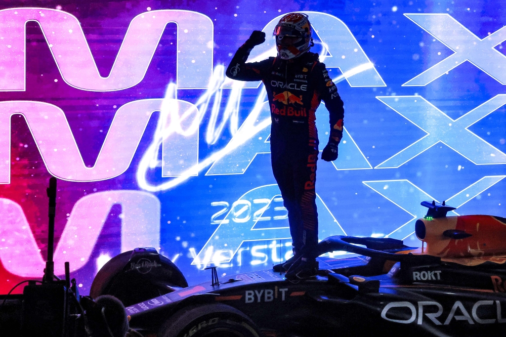 Red Bull Racing's Dutch driver Max Verstappen celebrates winning his third world title after the sprint race ahead of the Qatari Formula One Grand Prix at the Lusail International Circuit on October 7, 2023. (Photo by Giuseppe CACACE / AFP)
