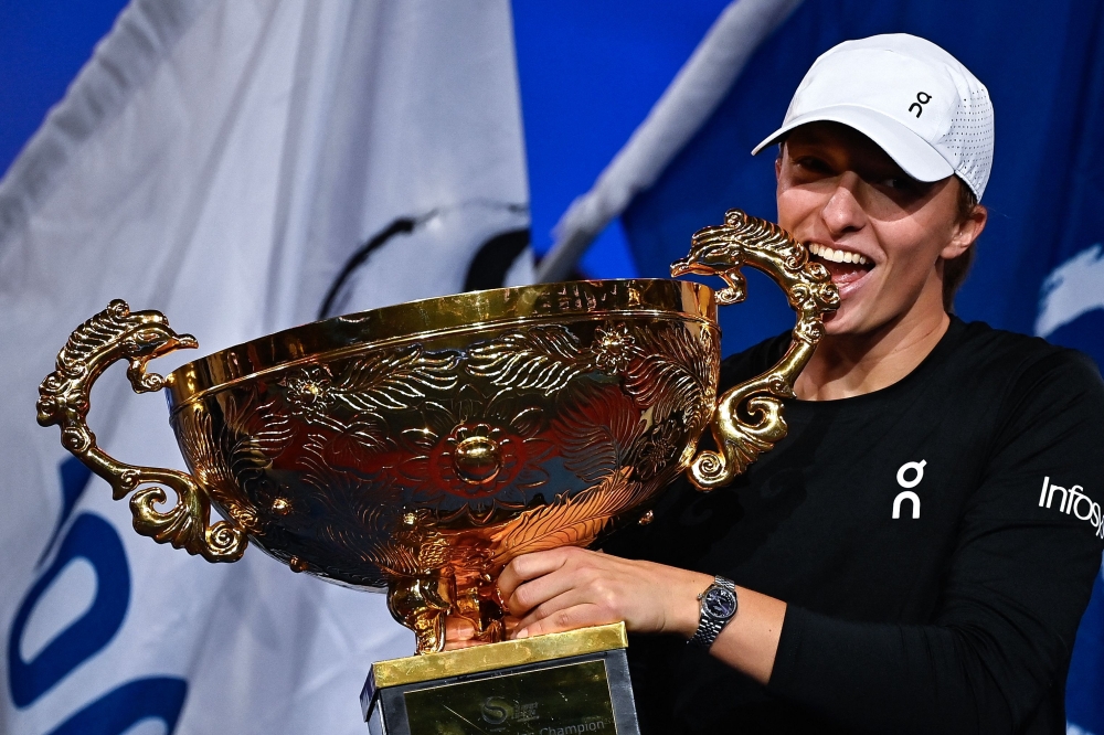Poland's Iga Swiatek holds the winning trophy after defeating Russia's Liudmila Samsonova in the women's singles final match of the WTA China Open tennis tournament in Beijing on October 8, 2023. (Photo by Pedro Pardo / AFP)