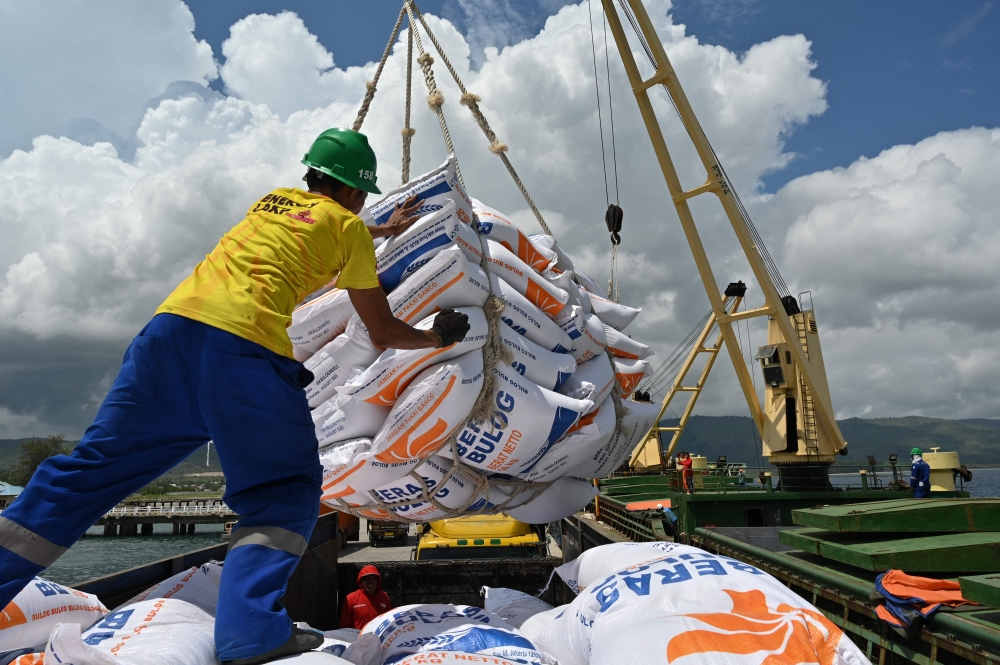Workers unload rice imported from Vietnam by the Indonesian Logistics Bureau at the port of Malahayati, in Indonesia's Aceh province on October 11, 2023. (Photo by CHAIDEER MAHYUDDIN / AFP)
