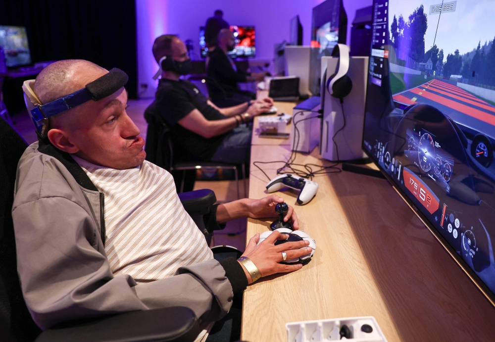 Jeremy Lecerf, also known as Mr Gyzmo, tries out the new Playstation Access controller at a demonstration event in London on October 5, 2023. (Photo by Henry Nicholls / AFP)