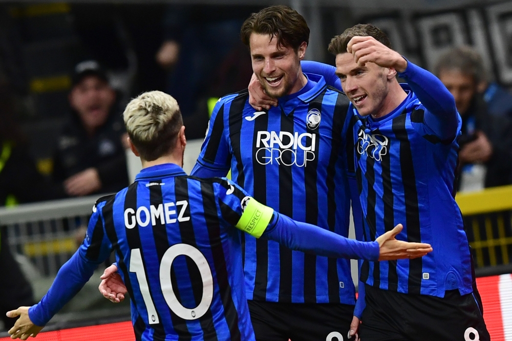 Atalanta's Dutch defender Hans Hateboer (C) celebrates with Atalanta's Argentinian forward Papu Gomez (L) and Atalanta's German defender Robin Gosens after opening the scoring during the UEFA Champions League round of 16 first leg football match Atalanta

