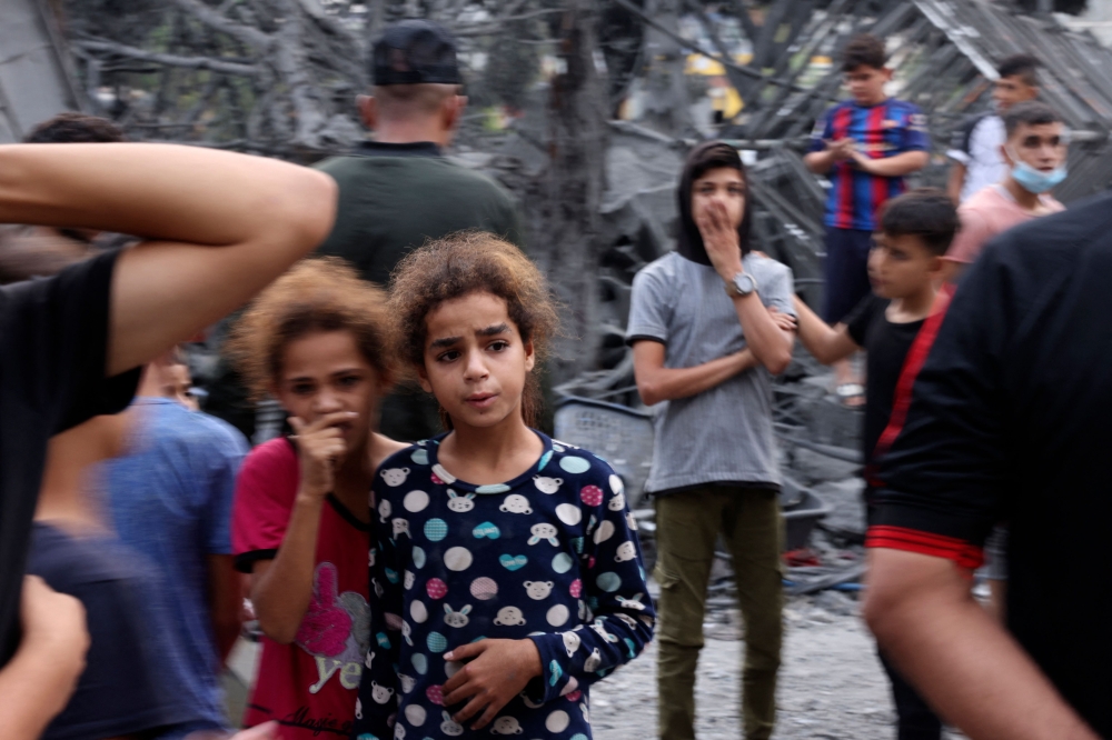 Palestinians gather near the rubble of a building following overnight Israeli strikes on the Rafah refugee camp in the southern Gaza Strip on October 25, 2023. Photo by Mohammed ABED / AFP