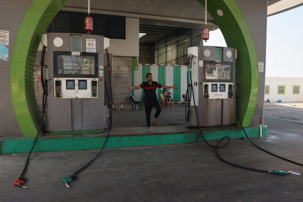 A Palestinian man gestures at a closed petrol station in the aftermath of Israeli strikes on the Rafah refugee camp in the southern Gaza Strip on October 25, 2023. (Photo by Said Khatib / AFP)