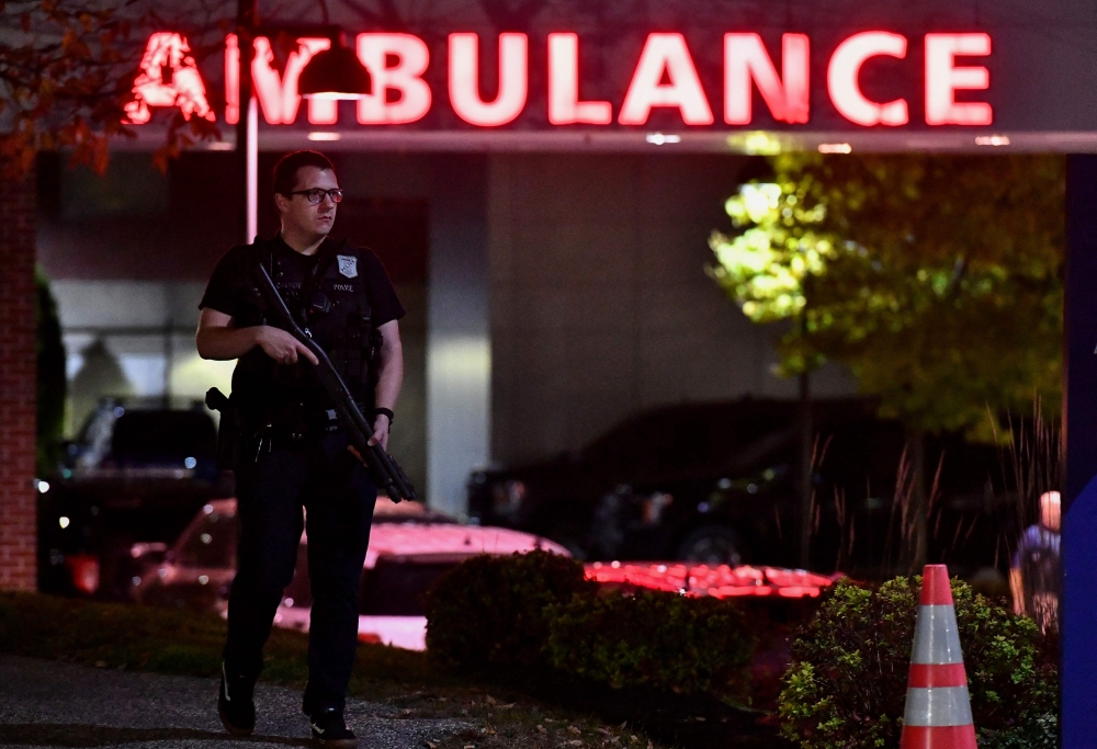 An armed police officer guards the ambulance entrance to the Central Maine Medical Center in Lewiston, Maine early on October 26, 2023. (Photo by Joseph Prezioso / AFP)
 