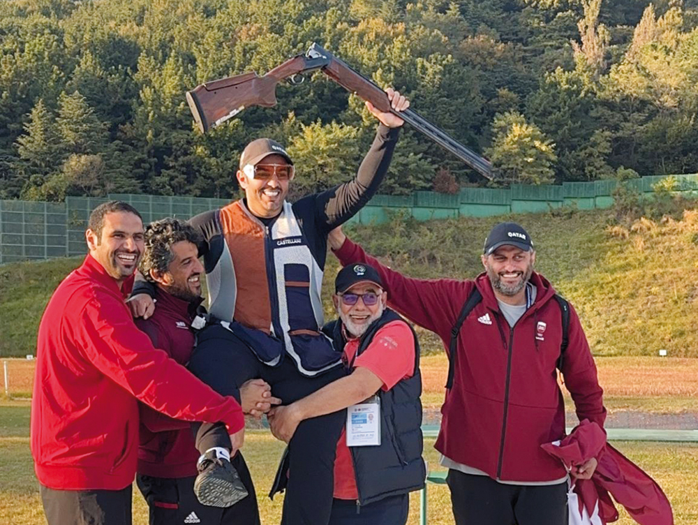 Qatar's Saeed Abu Sharib (centre) celebrates with teammates.