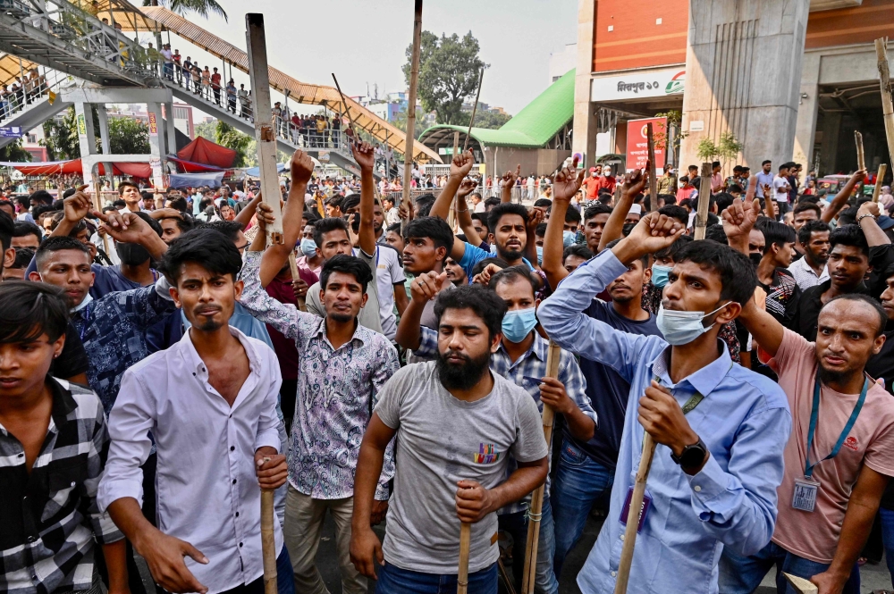 Garment workers block roads as they take part in a protest in Dhaka on November 1, 2023. (Photo by Munir Uz Zaman / AFP)