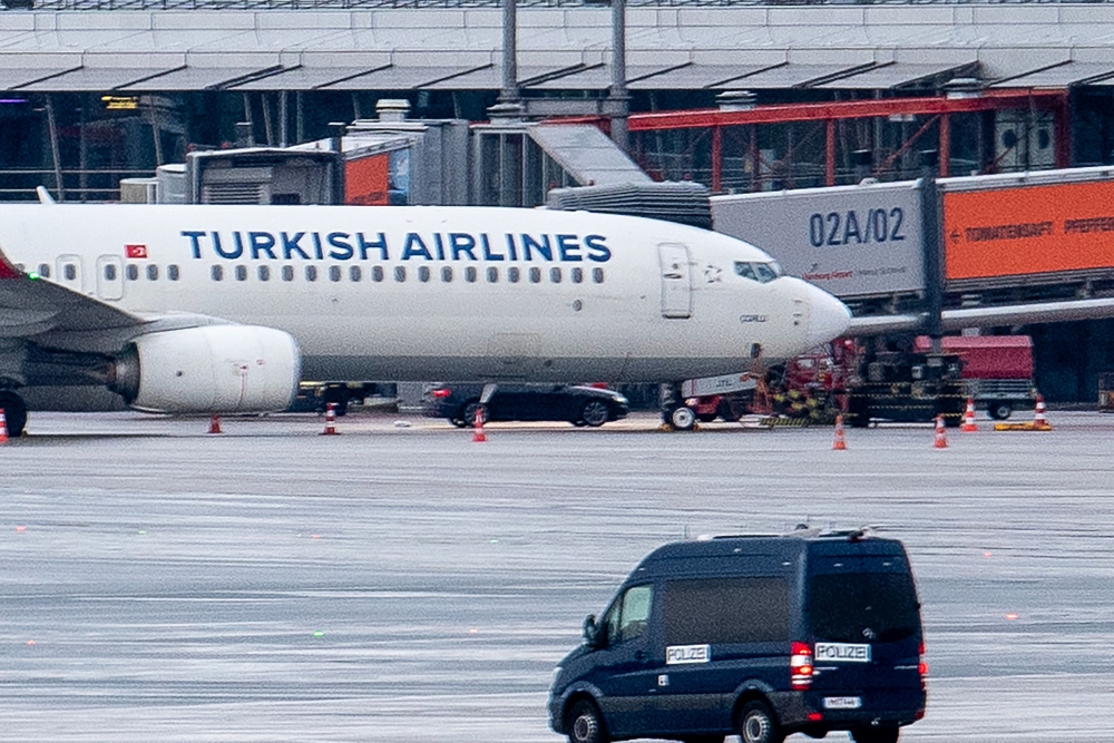 A police van observe the car of a hostage taker seen parked under a Turkish airline plane on the tarmac at the airport in Hamburg, northern Germany on November 5, 2023. (Photo by NEWS5 / Schrِder / NEWS5 / AFP)
