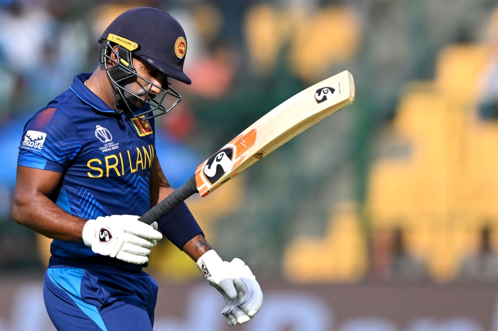 Sri Lanka's Chamika Karunaratne walks back to the pavilion after his dismissal during the 2023 ICC Men's Cricket World Cup one-day international (ODI) match between New Zealand and Sri Lanka at the M. Chinnaswamy Stadium in Bengaluru on November 9, 2023. (Photo by R.Satish Babu / AFP)