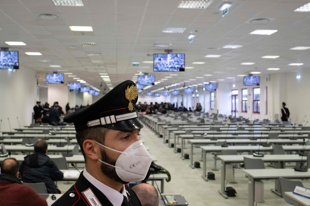 (FILES) A Carabinieri police officer wearing a face mask stands guard as a general view shows a special courtroom on January 13, 2021 on the opening day of the 'Rinascita-Scott' maxi-trial in which more than 350 alleged members of Calabria's 'Ndrangheta mafia group and their associates go on trial in Lamezia Terme, Calabria. (Photo by Gianluca CHININEA / AFP)
