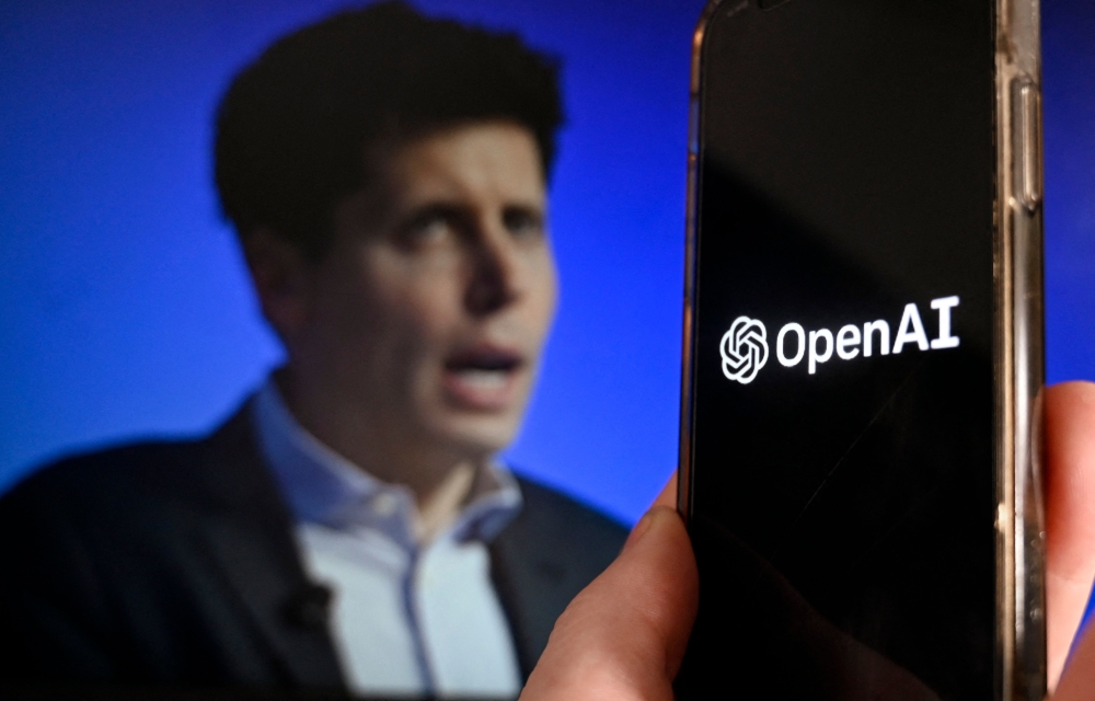 This illustration photo produced in Arlington, Virginia on November 20, 2023, shows a smart phone screen displaying the logo of OpenAI juxtaposed with a screen showing a photo of former OpenAI CEO Sam Altman attending the Asia-Pacific Economic Cooperation (APEC) Leaders' Week in San Francisco, California, on November 16, 2023. (Photo by Olivier Douliery / AFP)