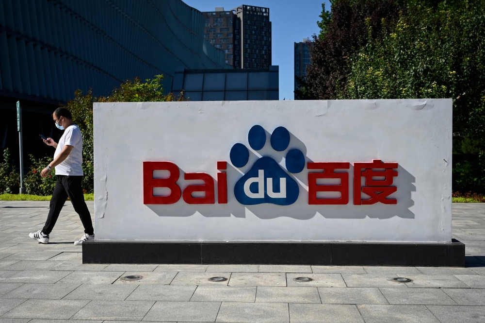 An employee walks past the company logo at Baidu's headquarters in Beijing on September 6, 2022. Photo by Jade GAO / AFP