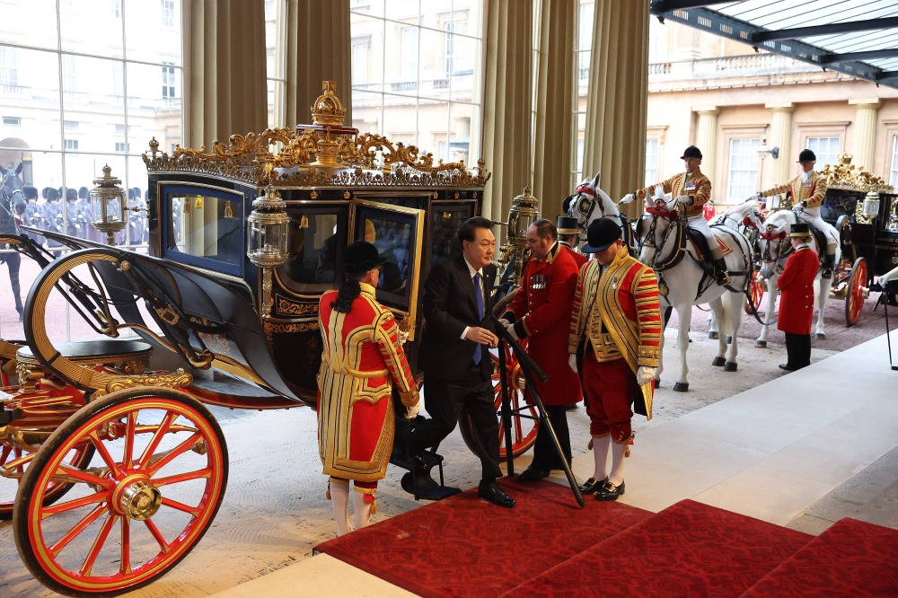 South Korea's President Yoon Suk Yeol arrives in the ceremonial State Carriage at Buckingham Palace in central London on November 21, 2023, on the first day of a three-day state visit to the UK. (Photo by Daniel Leal / POOL / AFP)