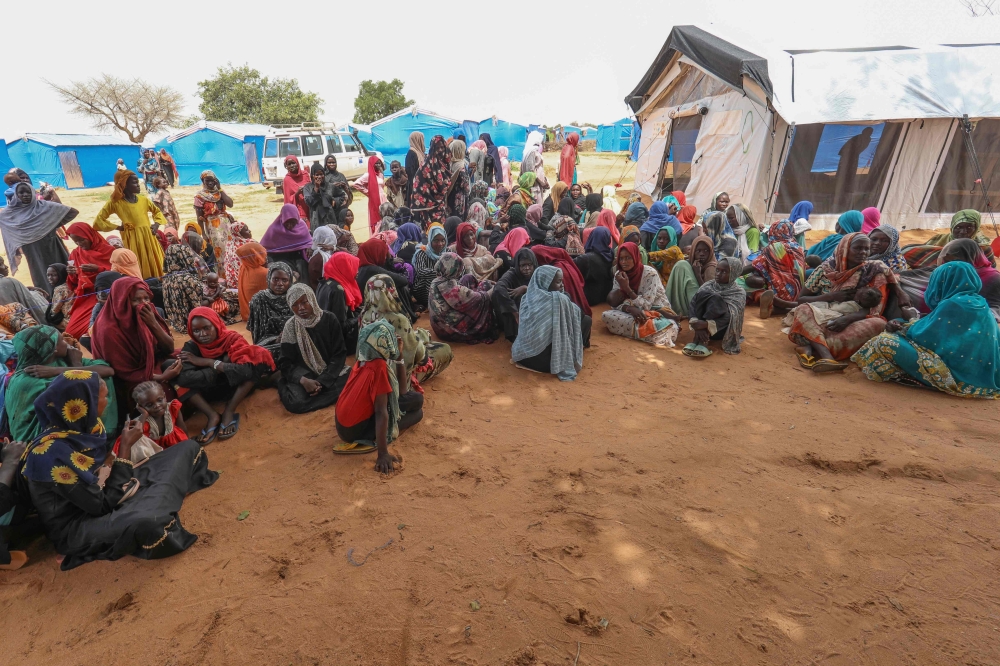Women who fled the war in Sudan await the distribution of international aid rations at the Ourang refugee camp, near Adre town in eastern Chad on August 15, 2023. (Photo by Mohaned Belal / AFP)