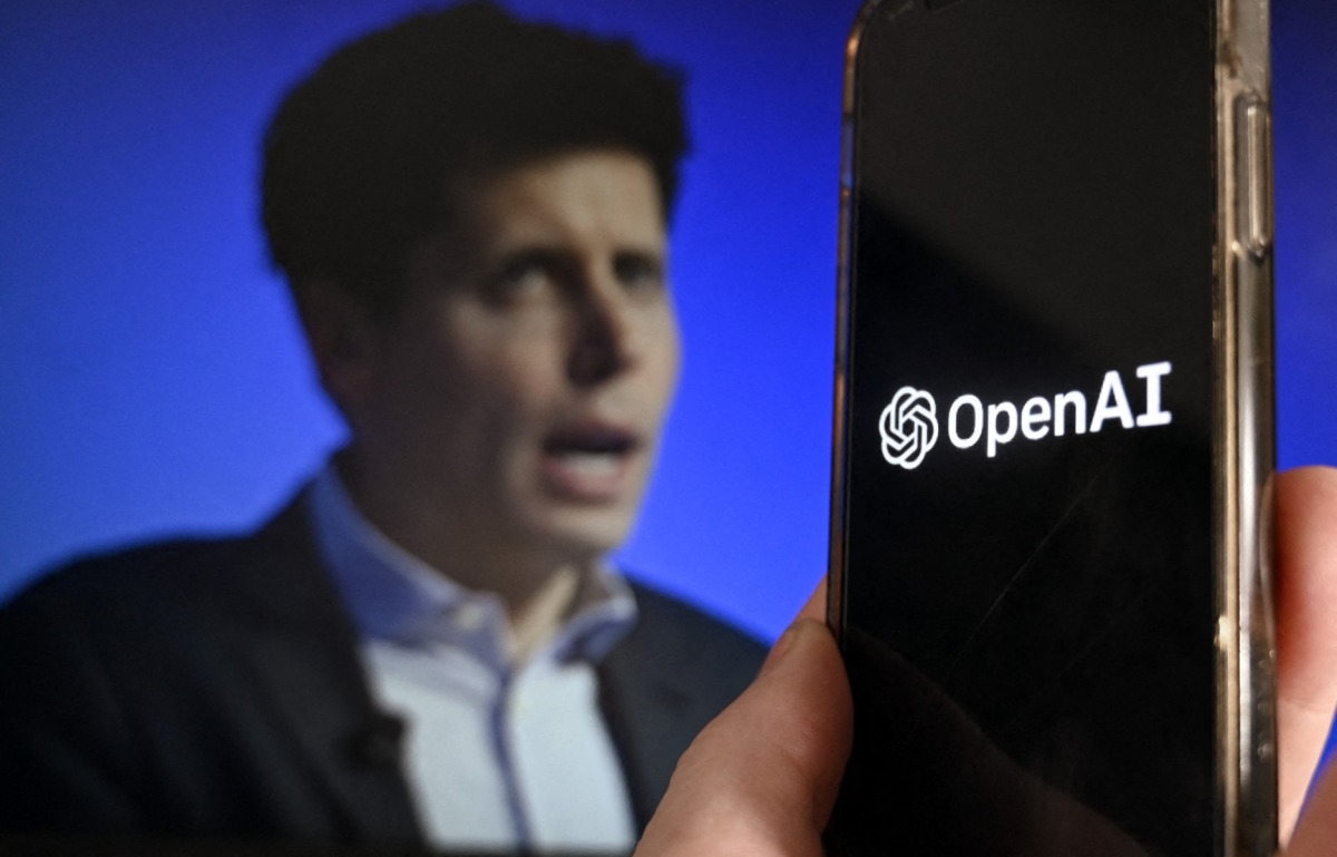 This illustration photo produced in Arlington, Virginia on November 20, 2023, shows a smartphone screen displaying the logo of OpenAI juxtaposed with a screen showing a photo of former OpenAI CEO Sam Altman attending the Asia-Pacific Economic Cooperation (APEC) Leaders' Week in San Francisco, California, on November 16, 2023. Photo by OLIVIER DOULIERY / AFP