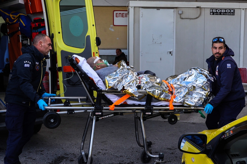 Medical staffs carry on a stretcher a survivor from the Comoros-flagged cargo ship that has sunk off the island of Lesbos, at a hospital on Lesbos Island on November 26, 2023. Photo by Manolis LAGOUTARIS / AFP