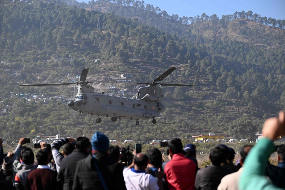 An IAF Chinook helicopter carrying rescued workers to a hospital in Rishikesh takes off at Chinyalisaur airstrip in Uttarakashi district of Uttarakhand State on November 29, 2023. (Photo by Sajjad Hussain / AFP)
 