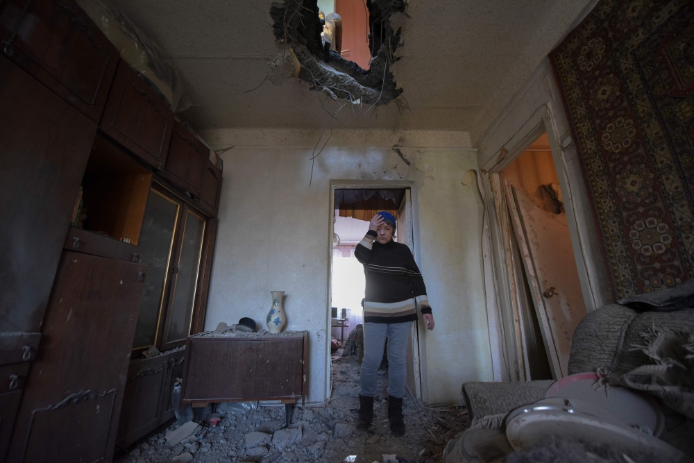 A local resident reacts standing inside her flat damaged by recent shelling in Donetsk, Russian-controlled Ukraine, on November 28, 2023, amid the Russia-Ukraine conflict. (Photo by STRINGER / AFP)

