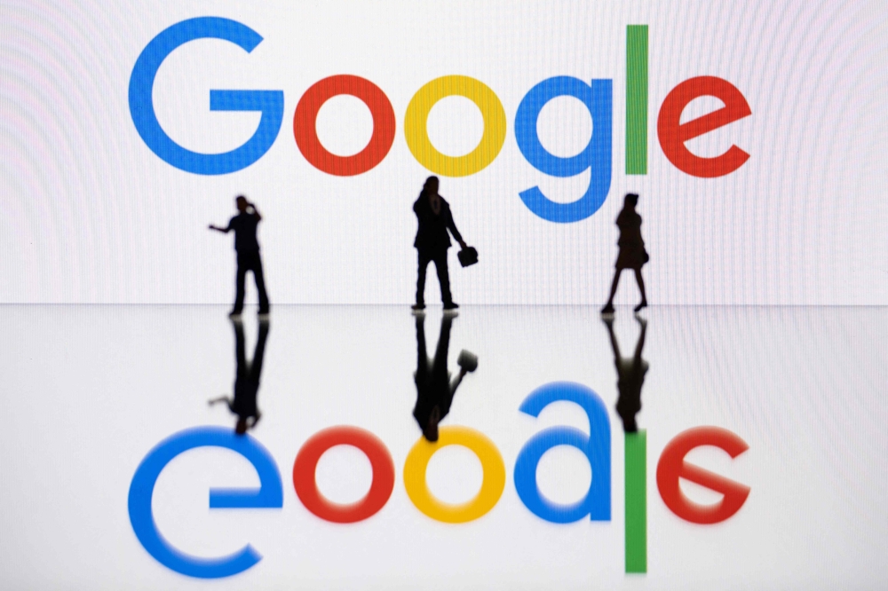 This illustration photograph taken on October 30, 2023 in Mulhouse, eastern France, shows figurines next to a screen displaying a logo of Google, a US multinational technology company. Photo by SEBASTIEN BOZON / AFP