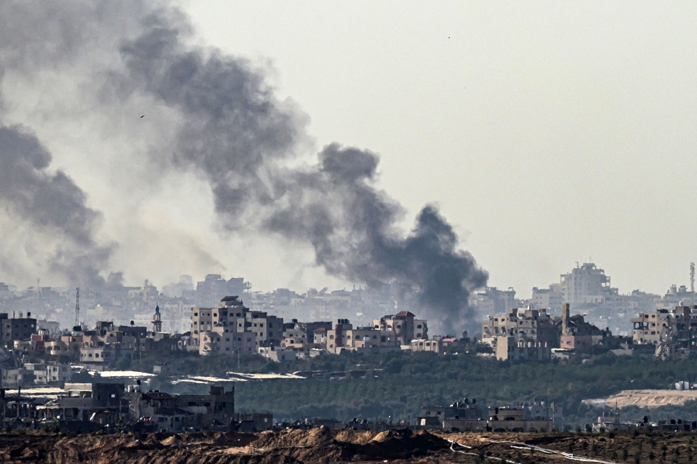 Smoke rising from buildings after being hit by Israeli strikes on December 2, 2023. (Photo by John MacDougall / AFP)