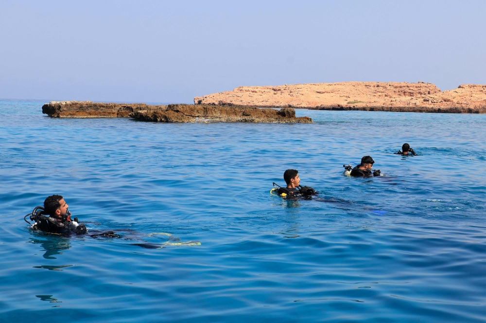 Volunteer divers remove fishing nets from coral reefs at Oman's Dimaniyat islands on October 4, 2024. (Photo by Karim Sahib / AFP)