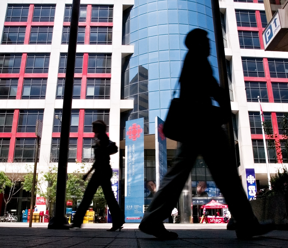 (FILES) Pedestrians walk in front of the Canadian Broadcasting Corporation (CBC) building in downtown Toronto on June 07, 2006. (Photo by GEOFF ROBINS / AFP)
