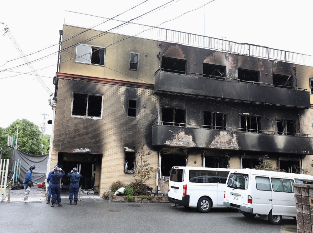 Japanese police officers inspect the scene where 36 people died in a fire at the Kyoto Animation studio building in Kyoto on July 19, 2019. Photo by JIJI PRESS / AFP