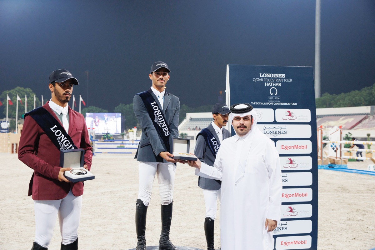 Head of Qatari equestrian teams Abdulla Al Marri presents the Medium Tour winner's trophy to Saeed Nasser Al Qadi on Day 1 of the sixth round of the Longines Hathab Qatar Equestrian Tour, at the Qatar Equestrian Federation’s outdoor arena, yesterday. 