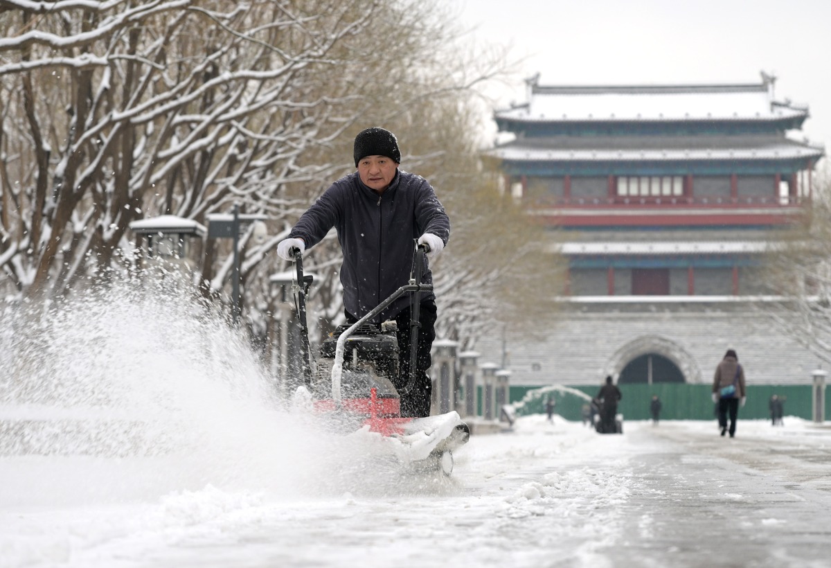 A worker removes snow with a machine at Yongdingmen Park in Beijing, capital of China, Dec. 11, 2023. Xinhua/Li He