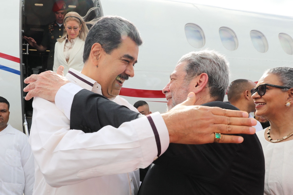 This handout picture released by the Venezuelan Presidency shows Venezuela's President Nicolas Maduro (left) greeting Prime Minister of Saint Vincent and the Grenadines Ralph Gonsalves after arriving at the Argyle International Airport in Saint Vincent and The Grenadines on December 14, 2023. (Photo by Zurimar Campos / Venezuelan Presidency / AFP)