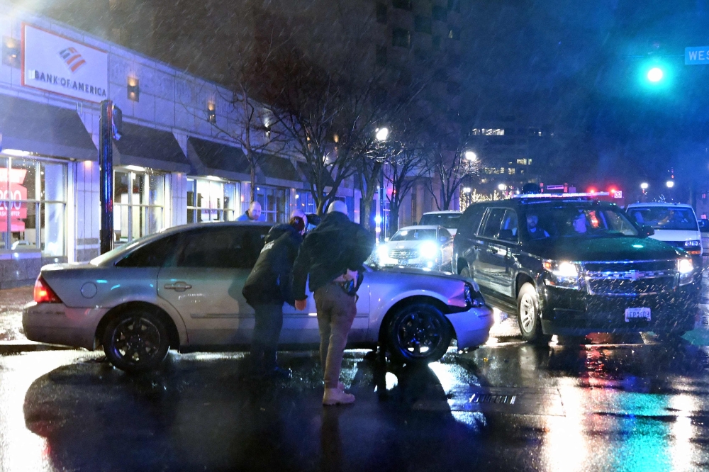 Members of the US Secret Service rush to a car, after it hit a motorcade SUV, as US president Joe Biden was leaving his campaign headquarters in Wilmington, Delaware on December 17, 2023. (Photo by ANDREW CABALLERO-REYNOLDS / AFP)
