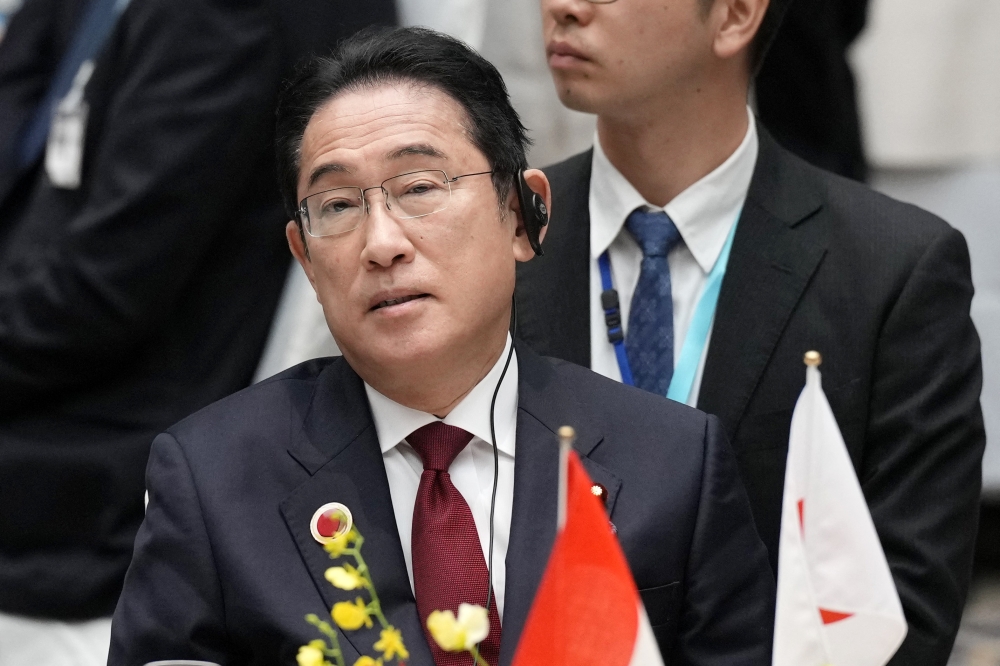 Japan's Prime Minister Fumio Kishida listens to the speech of Indonesia's President Joko Widodo at the 50th anniversary of ASEAN-Japan Friendship and Cooperation luncheon meeting at the Japan Business Federation (Keidanren) in Tokyo on December 18, 2023. (Photo by Eugene Hoshiko / POOL / AFP)
