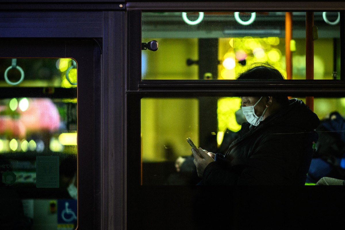 A commuter travels on a bus in Tokyo's Ginza district at dusk on December 13, 2023. (Photo by Philip FONG / AFP)