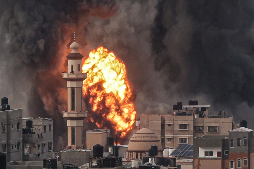 A fireball erupts after Israeli strike over Rafah in the southern Gaza Strip on December 20, 2023. (Photo by Said Khatib / AFP)
