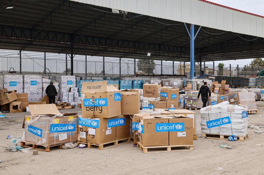 Boxes containing humanitarian aid are unloaded at the Karm Abu Salem (Kerem Shalom) crossing in Rafah in the southern Gaza Strip, on December 21, 2023. (Photo by Mohammed Abed / AFP)