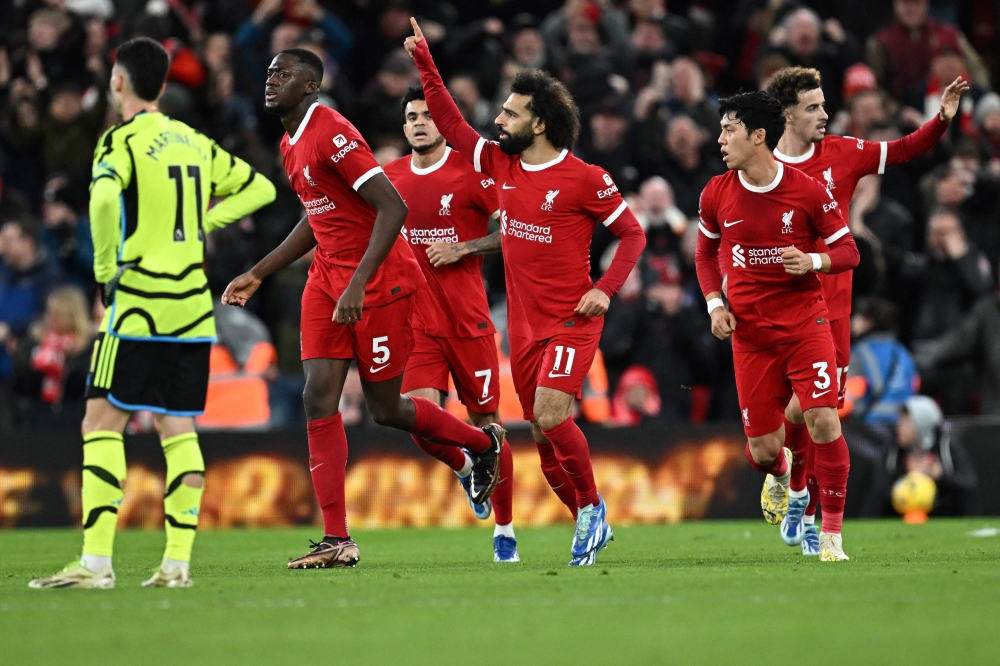 Liverpool's Egyptian striker #11 Mohamed Salah celebrates after scoring his team first goal during the English Premier League football match between Liverpool and Arsenal at Anfield in Liverpool, north west England on December 23, 2023. (Photo by Paul ELLIS / AFP)