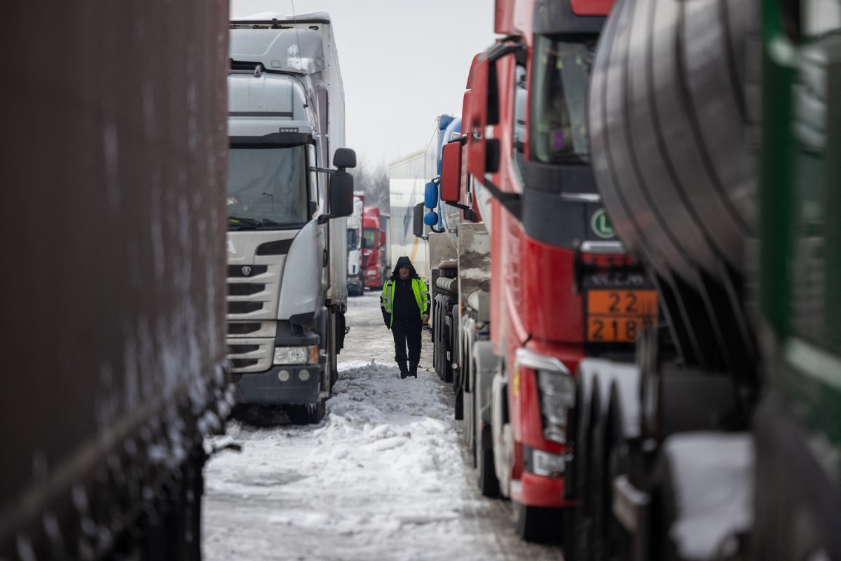 A Ukrainian truck driver is seen next to Ukrainian trucks on the parking lot near Korczowa Polish-Ukrainian border crossing, on December 5, 2023. (Photo by Wojtek Radwanski / AFP)